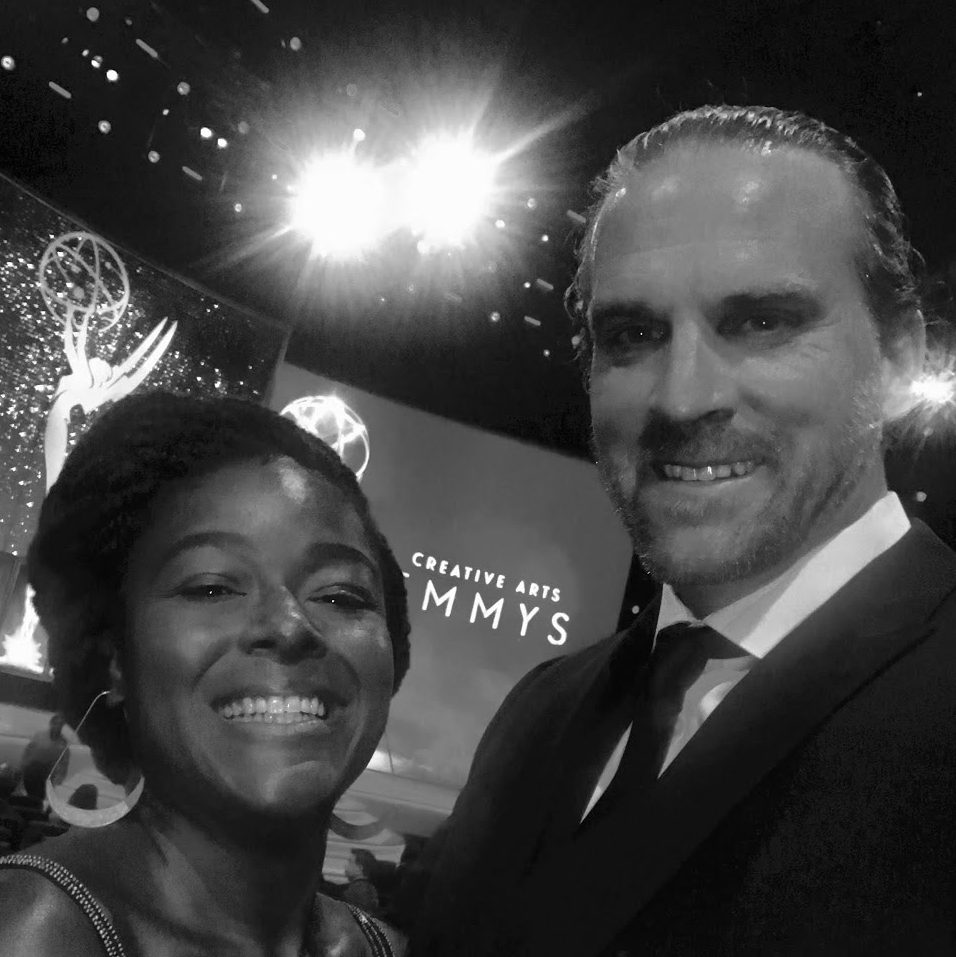 A man and woman posing for the camera at an emmys event.