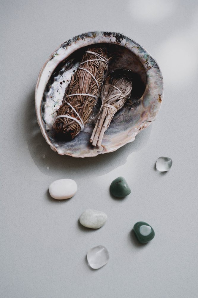 A bowl of herbs and stones on the table.